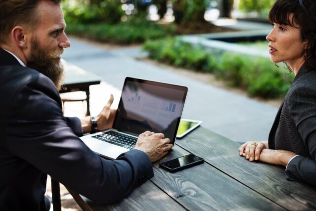 Two employees using communication skills at table