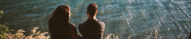 A couple sitting at ocean overlook engaged in conflict resolution processes