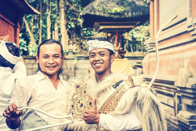 Two men posing together in traditional clothes intergroup contact