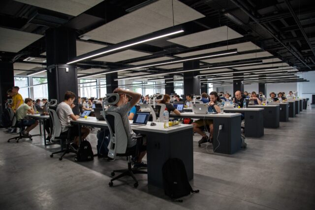 A workplace setting with many desks and people representing workplace conflict management