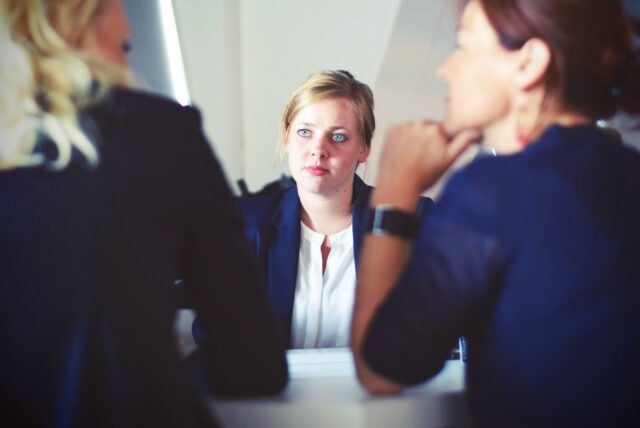 A woman resolving Conflict Between Two Employees