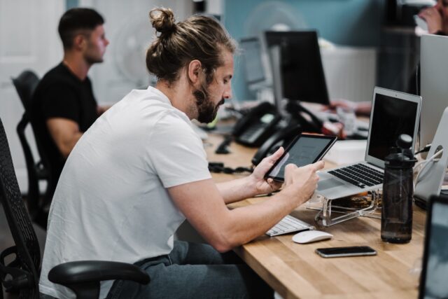 Man with introversion at work desk looking at iPad