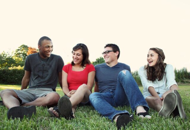 Group of young people engaging in intergroup dialogue on the grass