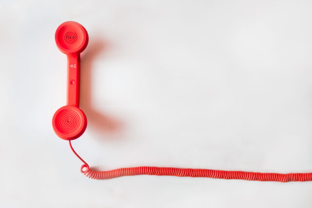 A red corded phone representing communication