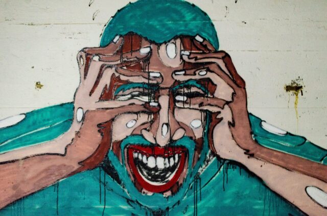 Mural of Blue-Haired Aggressive man with hands to face in need of deescalation training