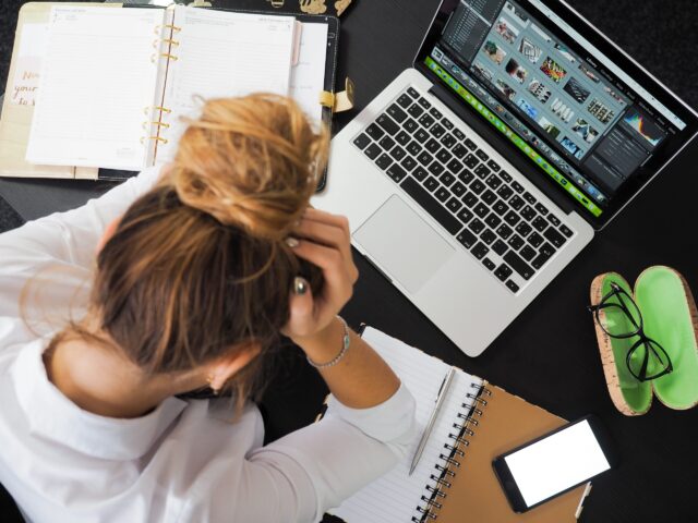 Stressed woman at computer symbolizing how to handle conflict when burned out