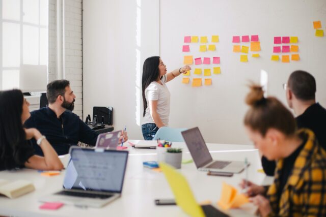 Group of employees in meeting using post-it notes to brainstorm about organizational justice