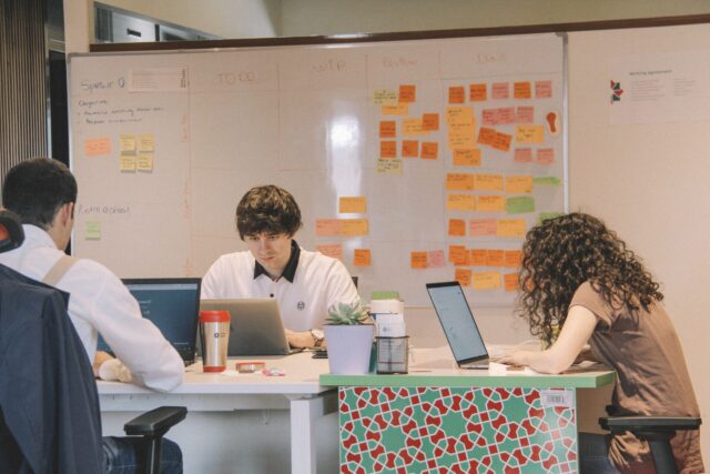 People at desk on laptops engaged in intergroup work