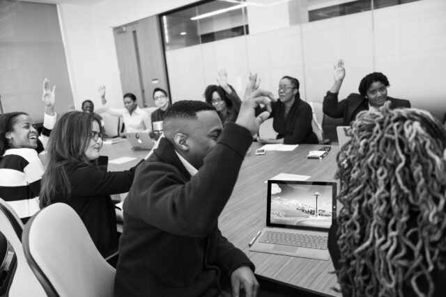 Group of people raising their hands indicating diversity training in the workplace