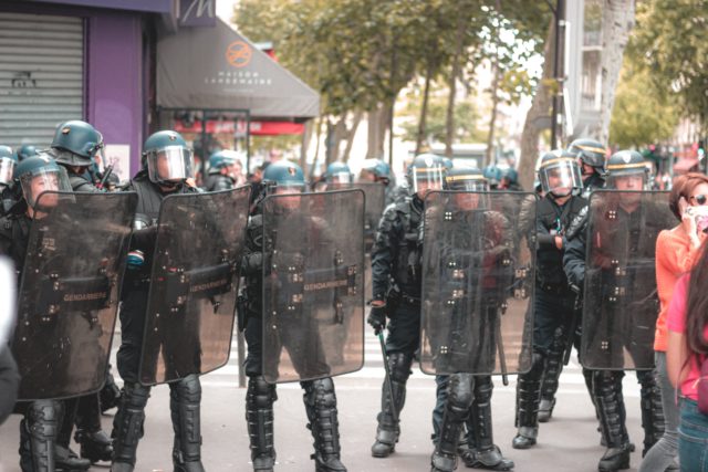 Police in riot gear standing in a row to prevent violence