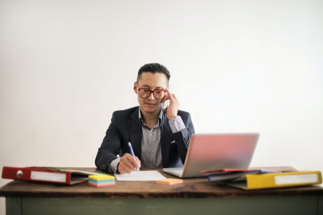 Man working from home at crowded desk trying to maintain work-life balance