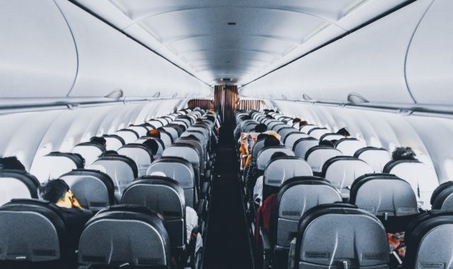 Inside of airplane with employees having gone through conflict resolution training for airline employees