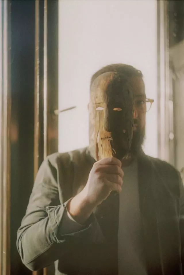 Man with mask, implying real or fake identity