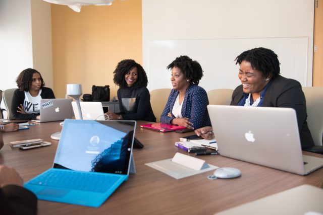 Three women at meeting at work talking about Factors Affecting Trust in the Workplace