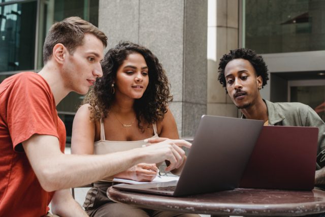 workplace team members gathered around computer showing team conflict management