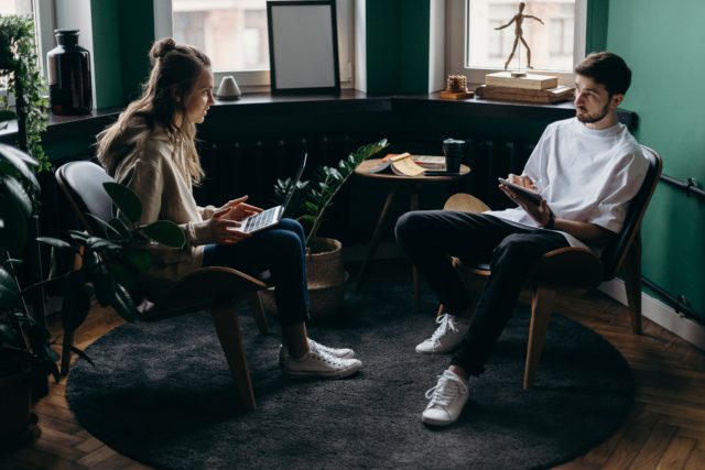 Two friends in chairs learning how to give a sincere apology