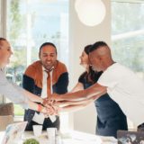Coworkers with hands together showing organizational culture