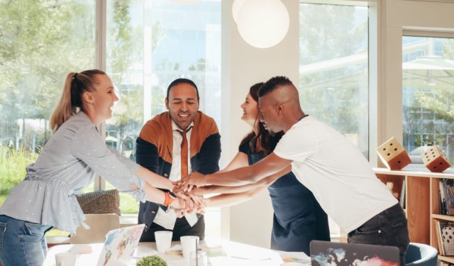 Coworkers with hands together showing organizational culture