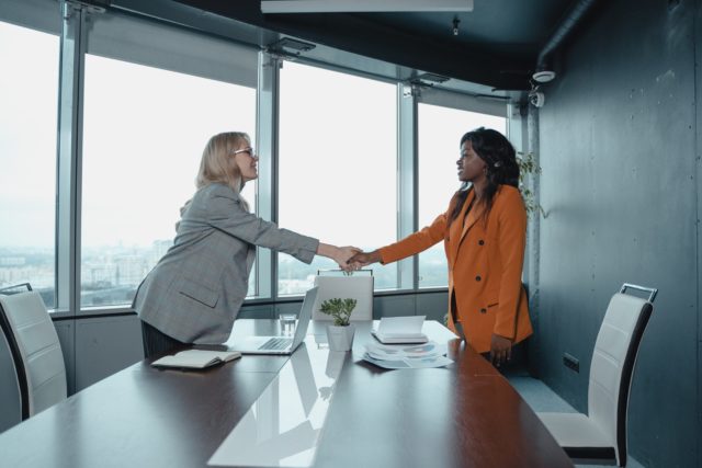 Two business partners shaking hands showing how to repair a relationship with a business partner