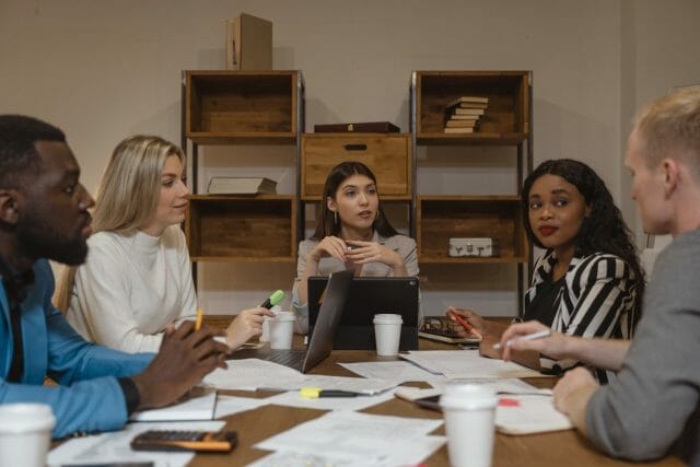 People sitting around a table discussing with documents over the table