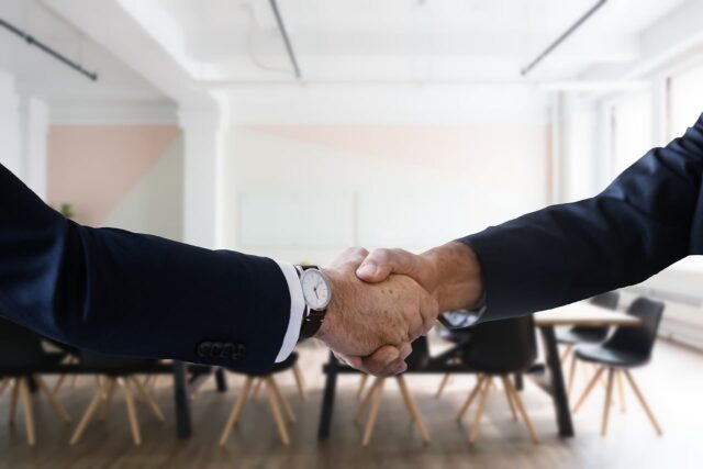 Two employees shaking hands showing professionalism