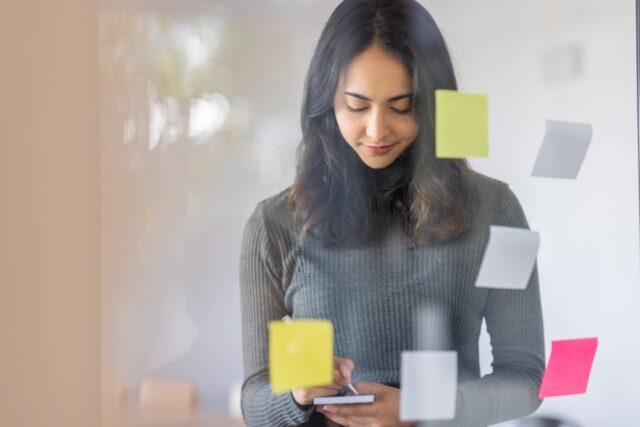 Woman writing down skills needed to develop for effective de-escalation