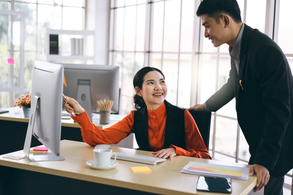 Young adult asian business people talking with each other.