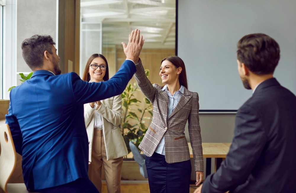 Motivated group of employees high-fiving each other