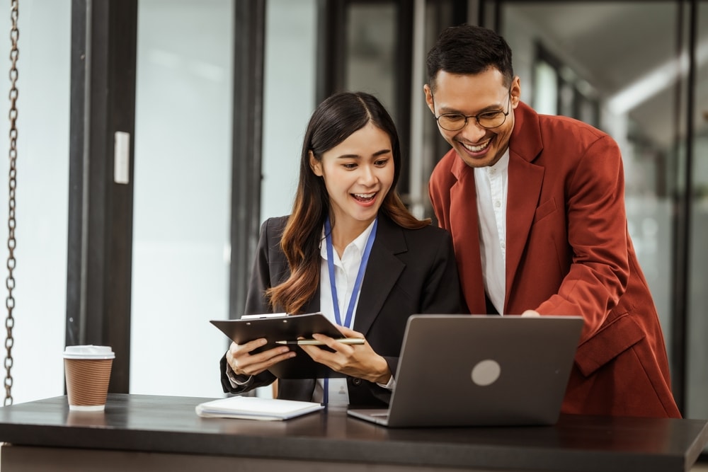 Two happy employees after task conflict resolution