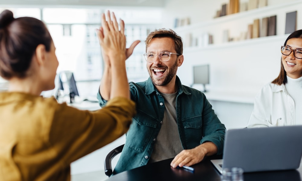 Happy man in workplace after overcoming recent burnout