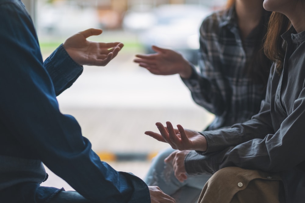 Closeup of hands of people sitting and talking together