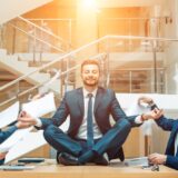Business negotiation, male partners arguing, funny easygoing man keeping calm in stressing situation, meditating with composed smile, dealing with emotional angry customer, stress management concept