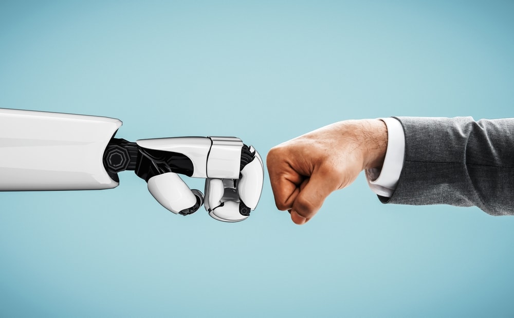 Closeup of a robot and human arm doing a fistbump