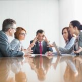 Two law firm partners meeting with a mediator to resolve a business dispute professionally