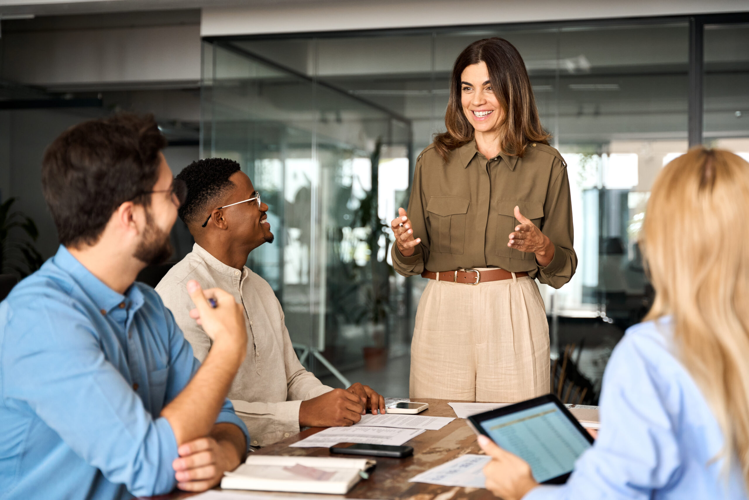 Happy middle aged business woman leader working with diverse team at meeting. https://pollackpeacebuilding.com/wp-content/uploads/2026/09/AdobeStock_722370823-scaled.jpeg